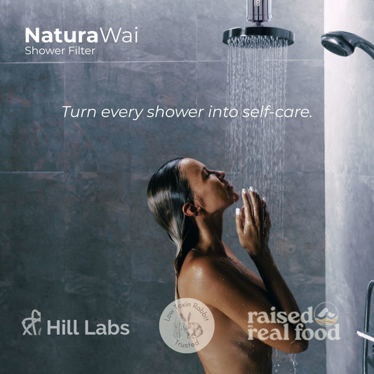 Woman showering with NaturaWai Shower Filter in a bathroom setting.